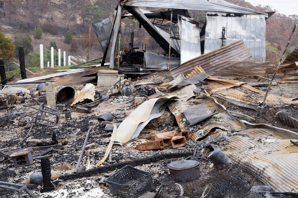 Item 19: Annette's property after the fire, with rubble, house and shed, Upper Kiah Road, New South Wales, 19 January 2020